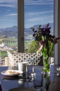 einen Tisch mit einer Vase aus Blumen und einem Fenster in der Unterkunft Casa Maiella by Rentbeat in Città Sant'Angelo