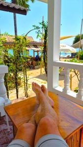 een man met zijn voeten op een bankje die uit een raam kijkt bij Mango Bungalow Tikki Beach Samui in Ban Thung