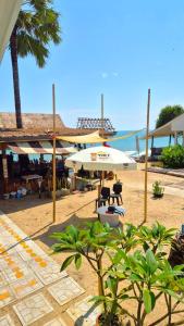 een strand met een witte parasol en stoelen en de oceaan bij Mango Bungalow Tikki Beach Samui in Ban Thung