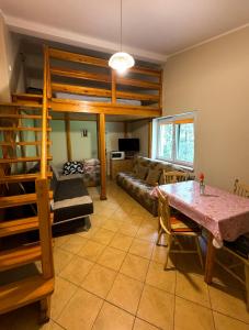 a living room with a loft bed and a table at Pokoje przy lesie in Jantar