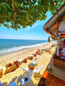 een strand met stoelen en tafels en de oceaan bij Mango Bungalow Tikki Beach Samui in Ban Thung +21 foto's