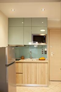 塞萨洛尼基Designer apartments close to the center + free parking的配有木质橱柜和不锈钢冰箱的厨房 更多8张照片