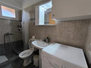 a bathroom with a white sink and a toilet at Aloda Summer House in Roda +36 photos