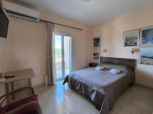 a bedroom with a bed and a sliding glass door at Aloda Summer House in Roda