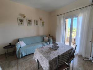 a living room with a blue couch and a table at Aloda Summer House in Roda