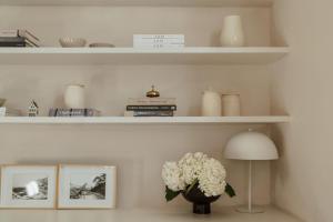 a shelf with a vase of flowers and a lamp at Cape Finest - De Waterkant House in Cape Town