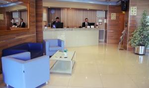 una hall con due uomini seduti al bancone di un ufficio di Hotel Reus Park a Reus