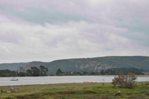 a large body of water with a boat on it at Keurbooms River Apartment in Plettenberg Bay