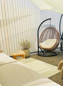 ein Rattanstuhl auf einem Balkon neben einem Bett in der Unterkunft shimagumi house 海のそばの小さな貸切り宿 in Kisarazu