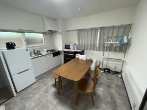 a kitchen with a wooden table and a refrigerator at フロンティアコート105号室 in Nagoya +8 photos