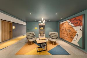a waiting room with two chairs and a painting at HIIVE by fusion Binh Duong - VSIP 1 in Thuan An
