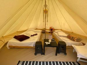 a tent with two beds and a table in it at Aurora Glamping in Vama Veche