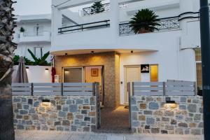 a building with two benches in front of it at Lambi beach City Suite in Kos