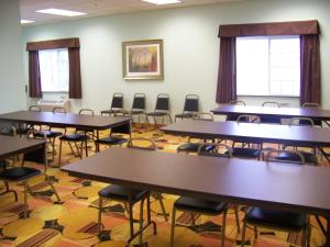 an empty classroom with tables and chairs in it at Days Inn & Suites by Wyndham Columbus NE in Columbus