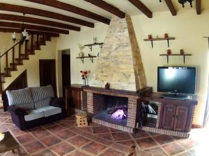 sala de estar con TV y chimenea en Casa Rural Entreparques en El Bosque