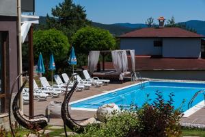 a swimming pool with rocking chairs and a swimming pool at Family Hotel The View & SPA in Tsigov Chark
