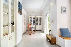 a hallway with white cabinets and a chair at Rosh HaNikra Garden Villa Retreat by Sea N' Rent in Sulam Tsor +71 photos