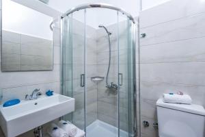 uma casa de banho com um chuveiro, um lavatório e um WC. em Floral Hotel em Hersonissos