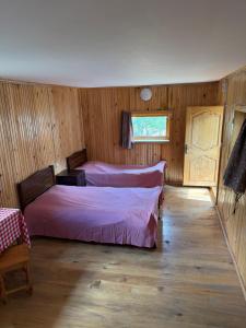メスティアにあるWooden Houseのベッド2台と窓のある寝室