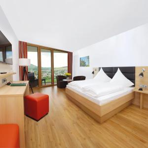 - une chambre avec un lit blanc et un tabouret rouge dans l'établissement Engener Höh, à Engen