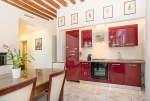 eine Küche mit roten Schränken und einem Esstisch in der Unterkunft Ca' Venezia Loc-09522 in Venedig
