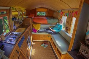 a woman sitting on a bench in a tiny house at 4x4 Mountain Cabin in Capel Curig +28 photos