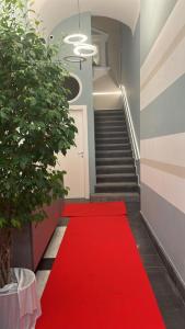 a red carpet in a hallway with a staircase at PALAZZO CHINIAL in Torre del Greco
