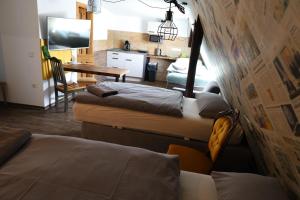 a room with two beds and a kitchen with a table at Gasthof Wedding in Bielefeld