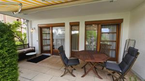 a porch with a wooden table and chairs on a patio at Ferienwohnung am Bodensee in Nonnenhorn