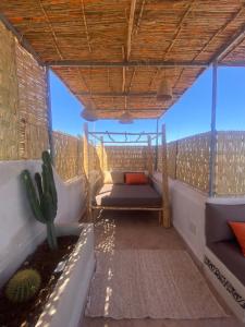 Un balcón con una cama y un cactus. en Riad ka, en Marrakech 25 fotos más