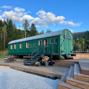 ein grüner Eisenbahnwaggon, der auf einer Brücke steht in der Unterkunft Hotel Telgárt - Turistické ubytovanie in Telgárt