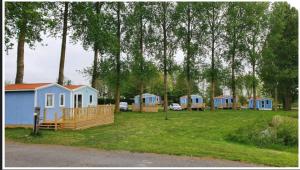 a group of tiny houses in a park with trees at Camping Le Romantic in Steenvoorde
