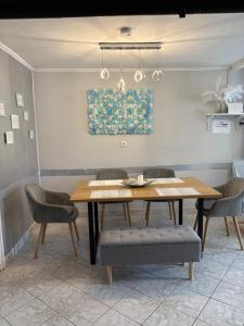 a dining room table with chairs and a painting on the wall at Napsugár vendégház in Mezőkövesd +42 photos