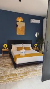 a bedroom with a large bed with yellow and blue walls at Ciss & Son Airport Lodge in Bounga