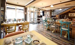 a restaurant with wooden tables and chairs and tablesearcher at ArtMotel & Bistro in Haţeg