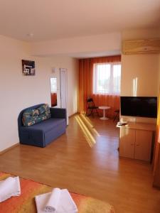 a living room with a couch and a flat screen tv at Къща за гости ГАЛАНТ in Byala