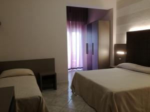 A bed or beds in a room at Hotel Fernanda