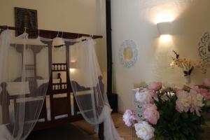 a bedroom with a bed with a canopy and flowers at Terre Di Vendicari in Noto