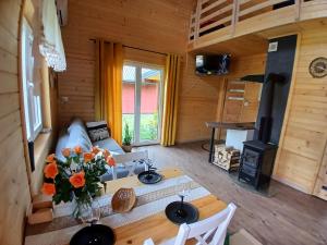 a living room with a couch and a table with flowers at Domki pod szybowiskiem in Lesko