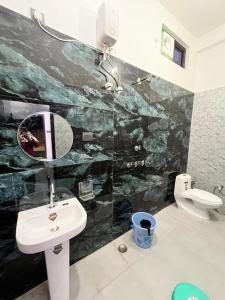 a bathroom with a sink and a toilet at Ananya Hotel & Restaurant in Naimishāranya +16 photos