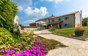 a house with purple flowers in front of a yard at Vila Azzura - Buje by Villas Guide in Buje