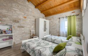 a bedroom with two beds and a stone wall at Vila Azzura - Buje by Villas Guide in Buje +24 photos