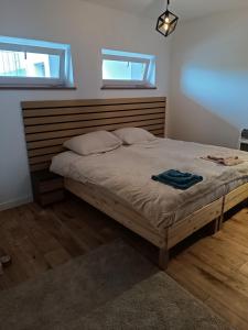 a bedroom with a large bed with a wooden headboard at Słoneczny Zakątek c in Złotów