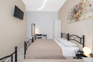 a white bedroom with a bed and a tv at B&B I Girasoli in San Donato Milanese