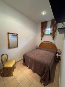 a bedroom with a bed and a chair and a mirror at Baccano Escape in Rome