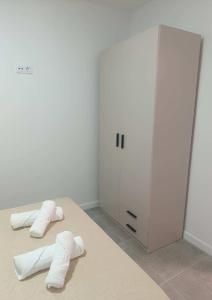 a room with two beds and a locker and towels at Entresueños de Arcos in Arcos de la Frontera