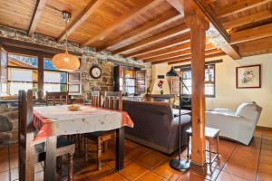 a kitchen and living room with a table and a couch at Valle de Bueida El Grillo in Rodiles