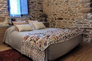 un letto in una stanza con un muro di pietra di La Cabaña San Pelayo a San Pelayo - Merindad de Montija