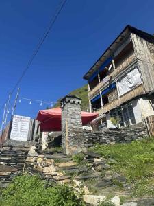 a building on top of a hill with a stone staircase at Century House of Larisa in Mestia