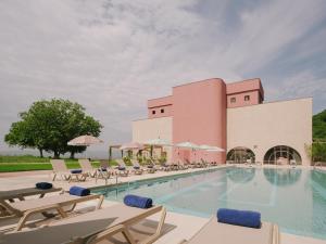 a swimming pool with chairs and a building at Pabellon Hotel in Kvareli